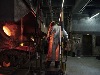 Industry, worker at furnace during melting copper, wearing a fire proximity suit