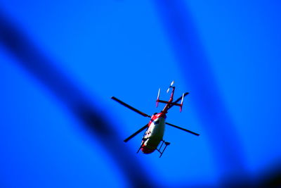 Low angle view of airplane against clear blue sky