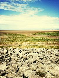 Scenic view of field against cloudy sky