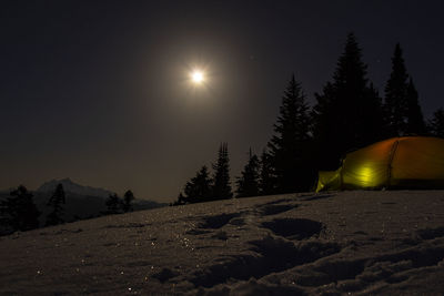 Scenic view of snow covered mountains against sky at night