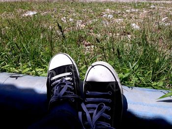 Low section of person wearing shoes on field