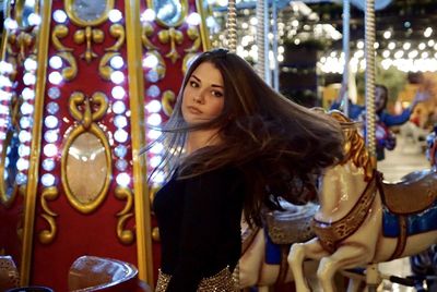Young woman in carousel at amusement park