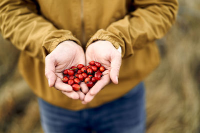 Midsection of man holding blueberries