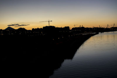 Silhouette of buildings at riverbank