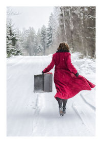 Rear view of woman walking in snow