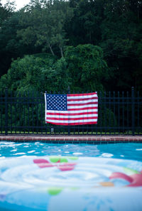 Red flag by swimming pool against trees