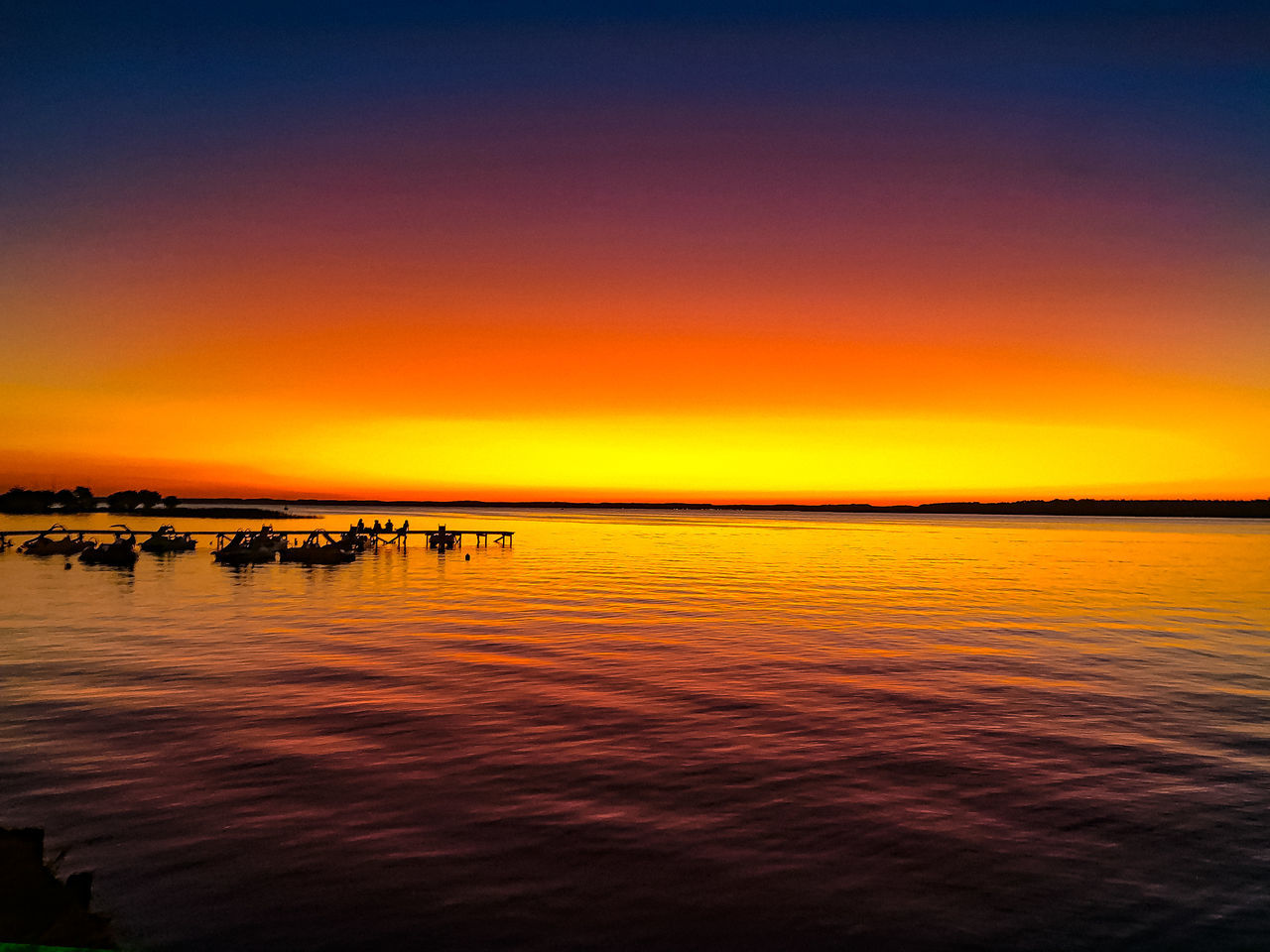 water, sky, sunset, beauty in nature, sea, scenics - nature, horizon, tranquility, dawn, tranquil scene, nature, orange color, afterglow, reflection, evening, idyllic, horizon over water, silhouette, no people, ocean, outdoors, beach, cloud, non-urban scene, land, waterfront, travel destinations, sunlight, dramatic sky