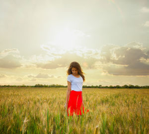 Woman standing on field against sky