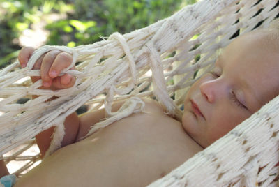 Close-up of baby relaxing in hammock outdoors