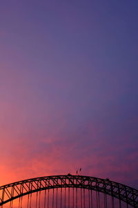 Silhouette sydney harbor bridge against sky during sunset