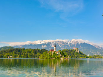 Scenic view of lake and mountains against blue sky