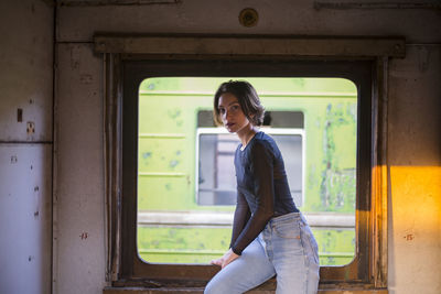 Portrait of beautiful woman leaning on window in train