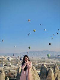 Portrait of woman against hot air balloons in sky