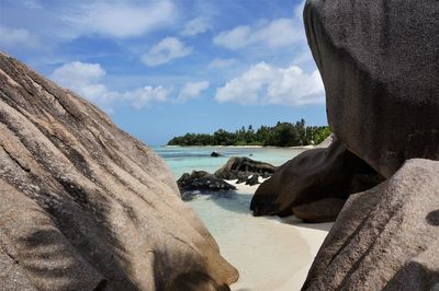 Rock formation on beach against sky