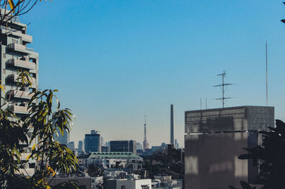 Buildings in city against clear blue sky