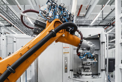 Orange robotic arm at electrical industry