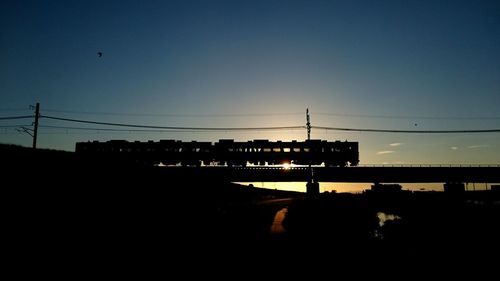 Electricity pylon against sky at sunset