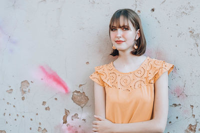 Portrait of woman standing against wall