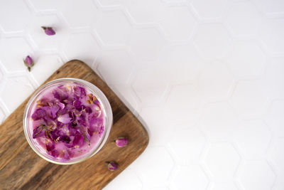 Pink rose milk with rose petals on a cutting board. healthy drink moon milk. copy space.