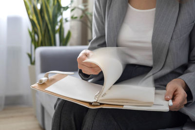 Midsection of woman reading book