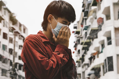 Portrait of man standing in city during winter