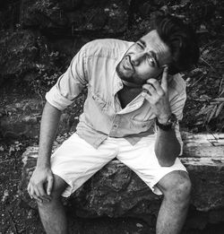Full length of man sitting outdoors