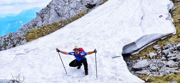 Man with umbrella on snowcapped mountain