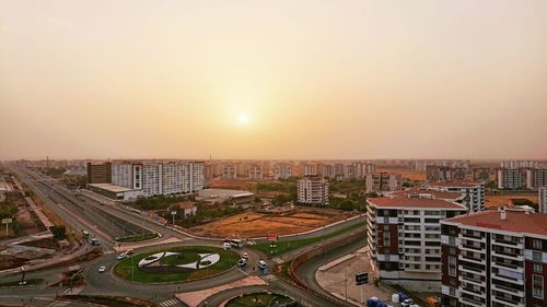 High angle view of city buildings against sky during sunset