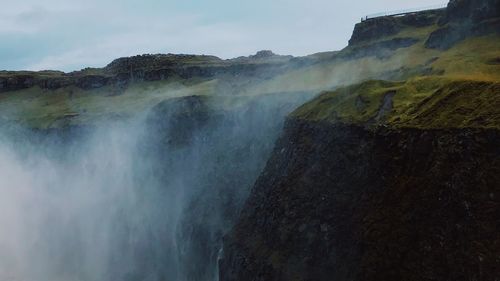 Scenic view of waterfall against sky