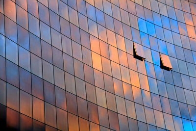 Low angle view of glass building against sky