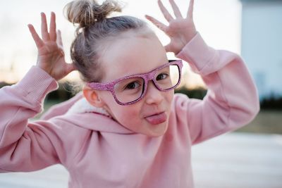 Portrait of a young girl pulling silly faces with sparkly glasses on