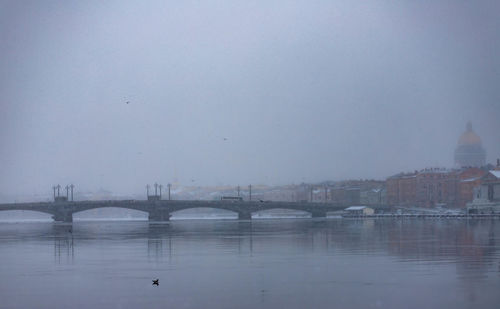 Bridge over river against buildings in city