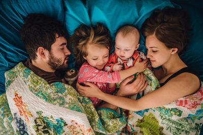 Mom and dad and children sleeping and hugging in bed in the morning