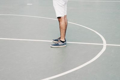 Low section of man standing on basketball court