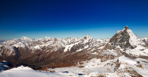 Snowcapped mountains against clear blue sky