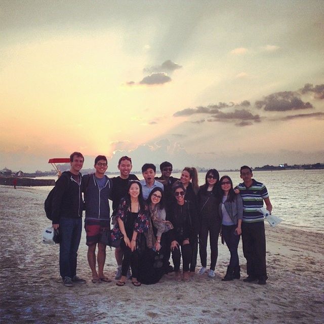 sunset, lifestyles, men, sky, leisure activity, sea, water, person, togetherness, beach, large group of people, rear view, shore, vacations, orange color, standing, cloud - sky, horizon over water, bonding