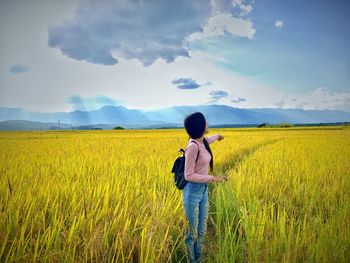 Woman standing on field against sky