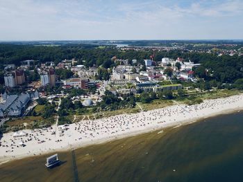 High angle view of buildings by sea against sky