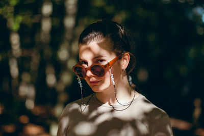 Portrait of woman wearing sunglasses standing outdoors