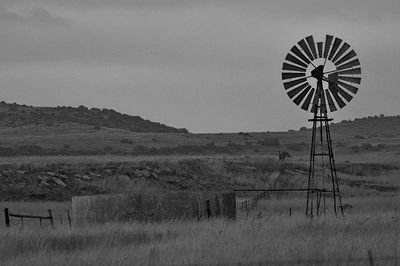 Windmill on field against sky
