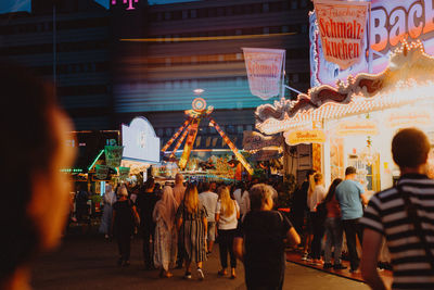 Group of people in amusement park at night