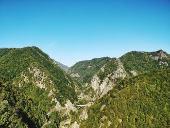 Scenic view of mountains against clear blue sky
