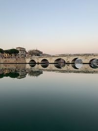 Arch bridge over river against clear sky