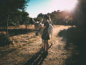 Directly above shot of woman standing on field against clear sky