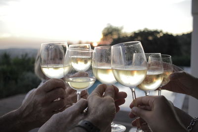Close-up of hands toasting champagne flutes