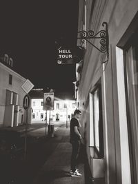 Full length of man standing on footpath by building