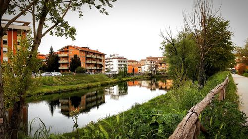 River amidst trees and buildings against sky