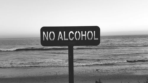 Close-up of information sign on beach