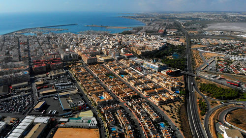 High angle view of buildings by sea against sky