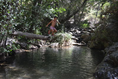 Low section of man feeding birds in water